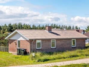 A single-story brick building with a gabled roof, a front door, and a small window. - 7 Person Holiday Home in Frostrup (Frøstrup)