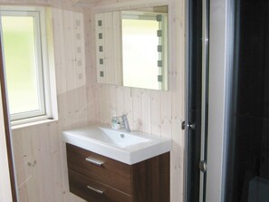 Bathroom features a sink, mirror, and window.