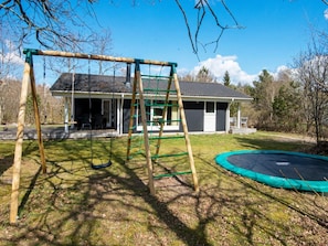 A residential property with a swing set, trampoline, and a house with a porch. - 6 Person Holiday Home in Silkeborg (Silkeborg)
