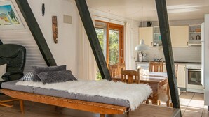 A cozy room with a wooden sofa, a dining table, and a kitchen area. - Seaside Spa Retreat - By Traum Ferienwohnungen (Haderslev)