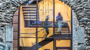 A modern building with a stone facade and a glass entrance.