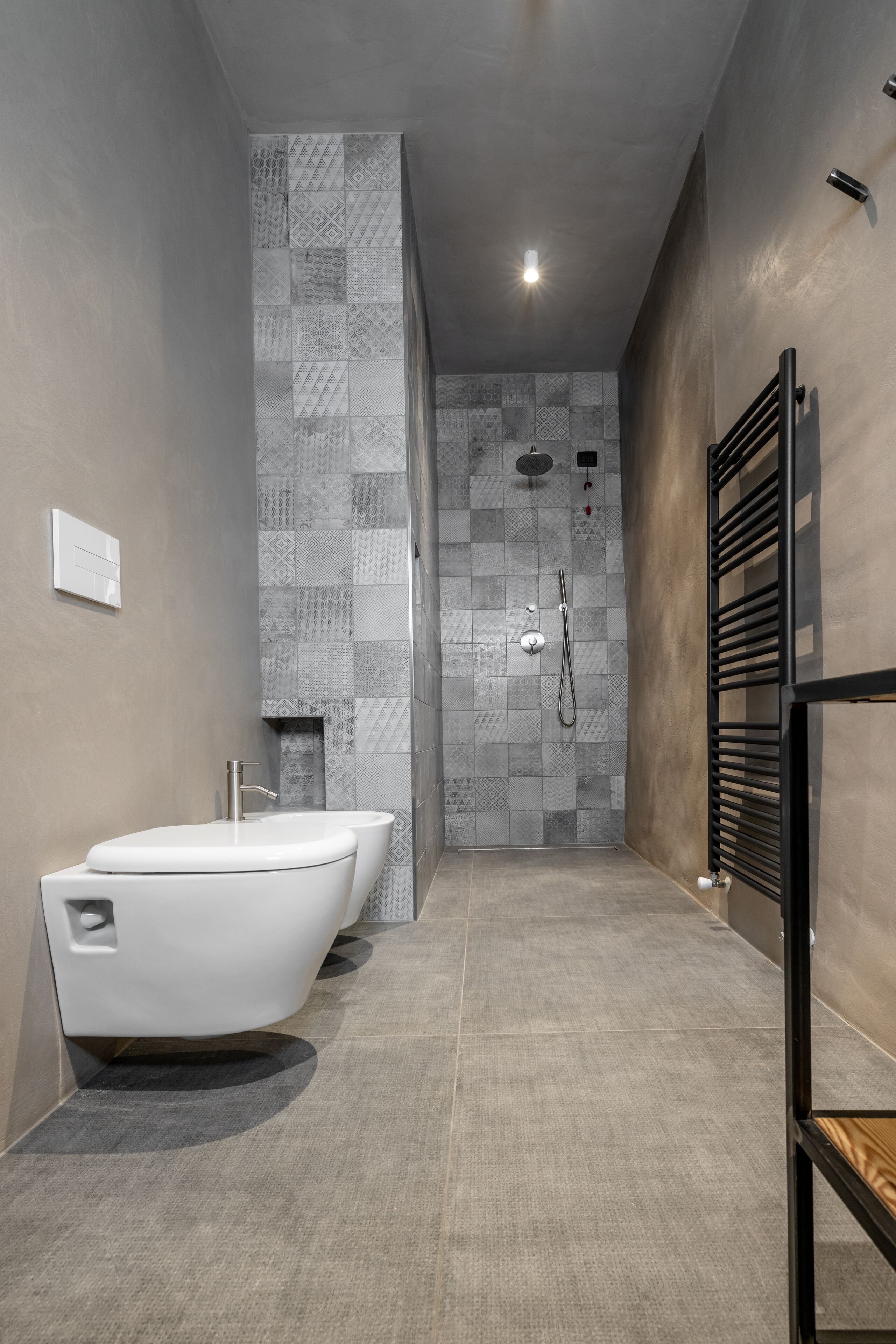 Een moderne badkamer met een vrijstaand bad, douche en toilet.