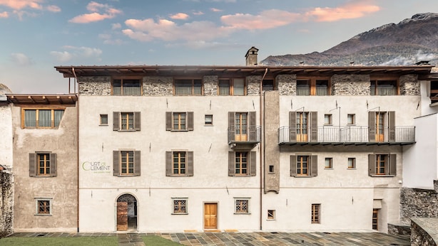 A historic building with a stone facade, multiple balconies, and a wooden door.