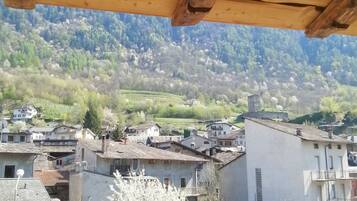 Une vue sur un village avec des bâtiments traditionnels et une chaîne de montagnes en arrière-plan.