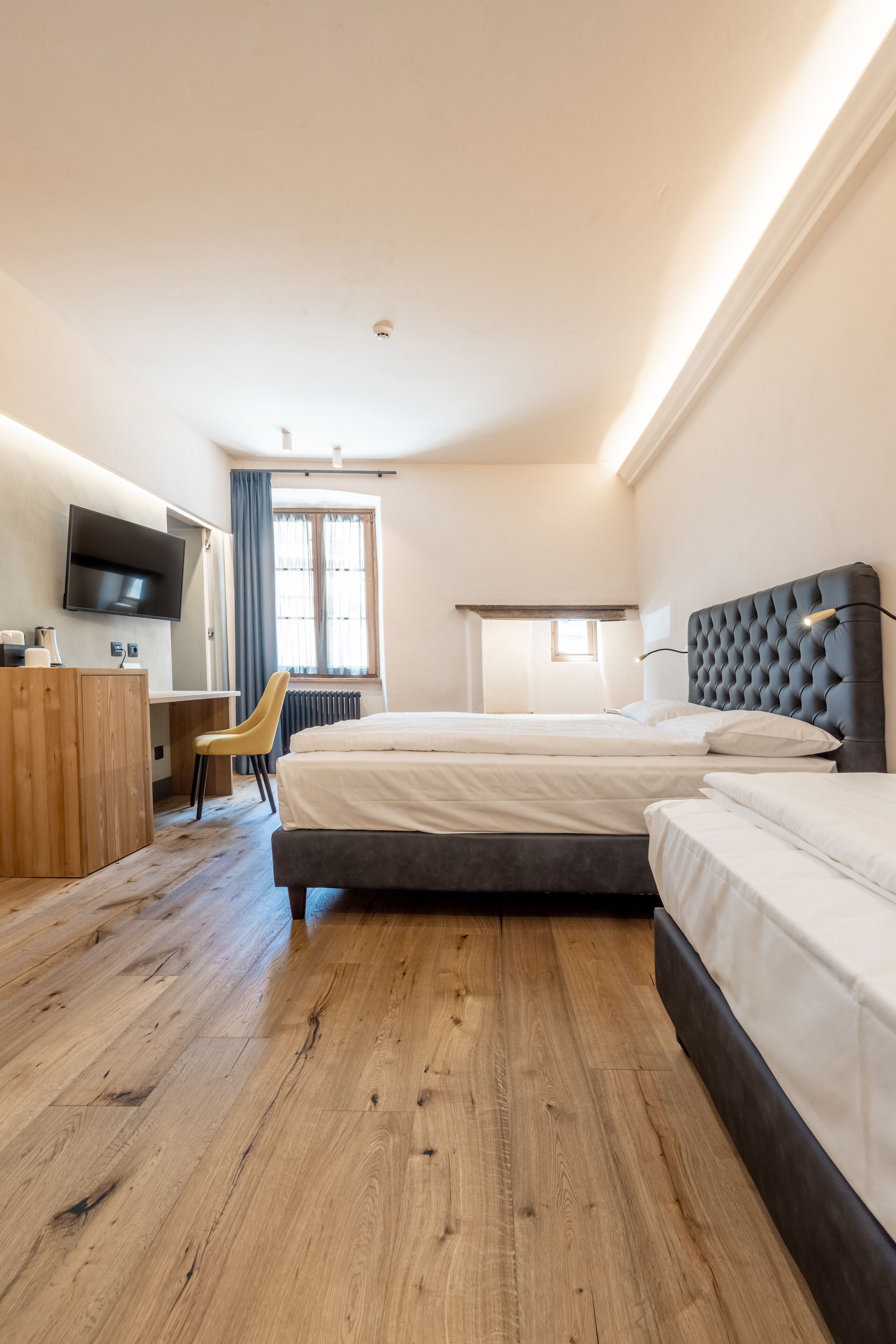 Una habitación de hotel con una cama grande, un escritorio, una silla y un televisor.