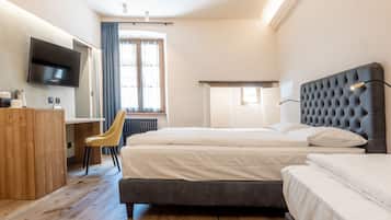 Una habitación de hotel con una cama grande, un escritorio, una silla y un televisor.