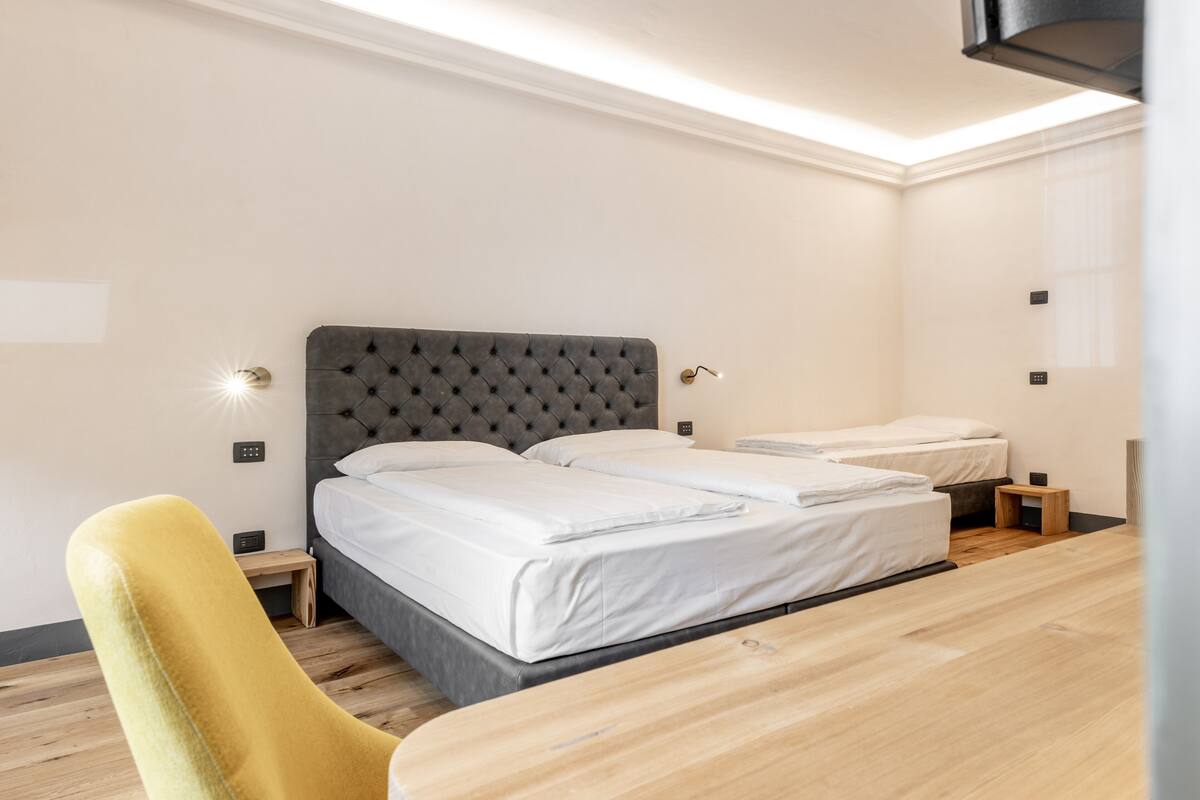 Ein Hotelzimmer mit einem großen Bett, einem kleinen Tisch und einem Sessel.