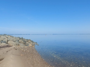 Una orilla tranquila con costa rocosa y cielo despejado.