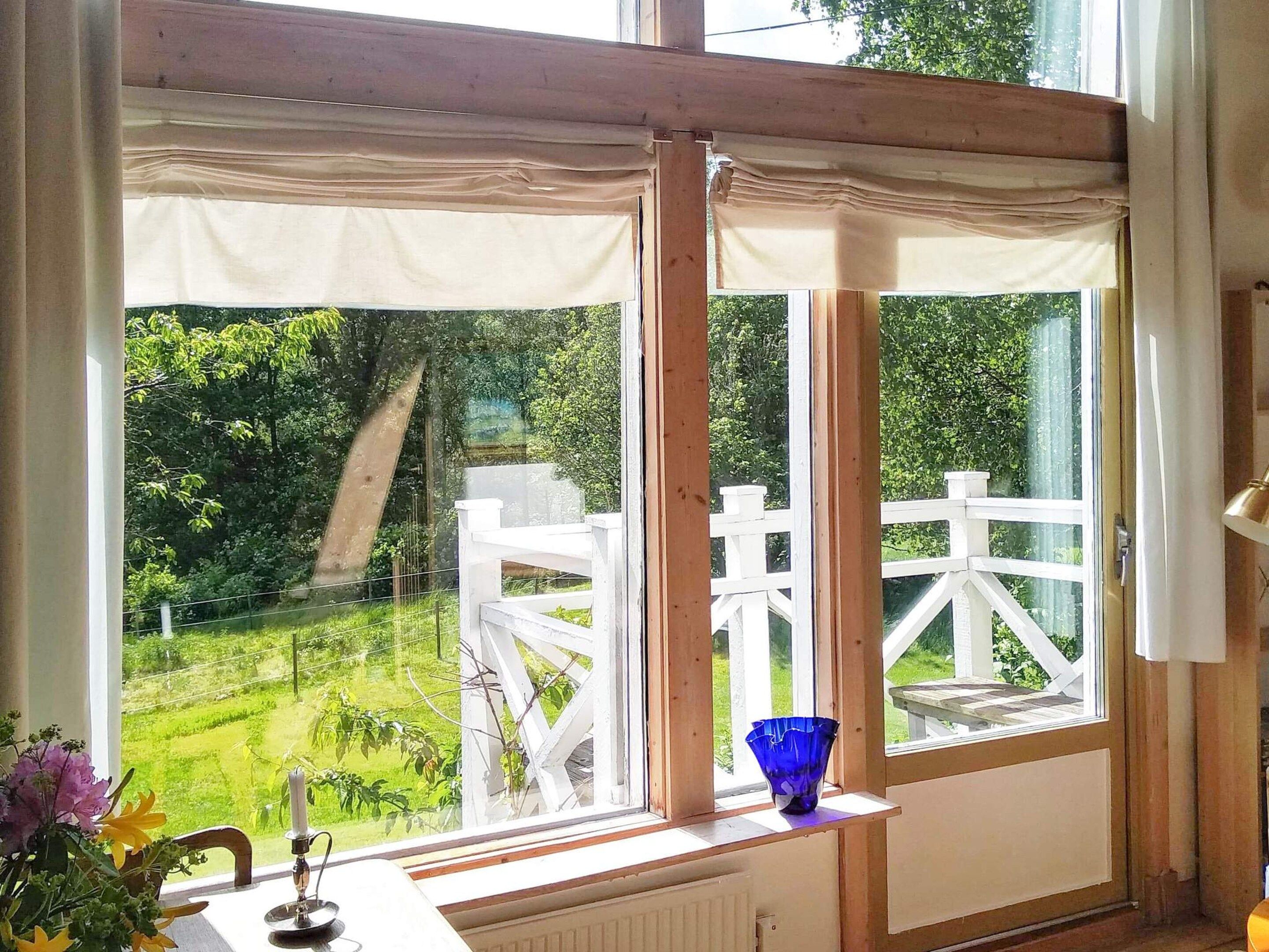 Habitación con vista a una cerca blanca y follaje exterior.