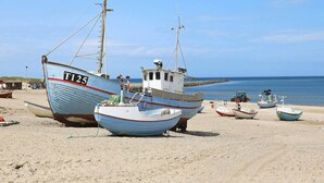 A beach with several boats, including a large one with the number T125. - 10 Person Holiday Home in Thisted (Thisted)