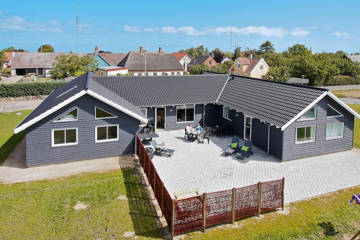 Ein modernes, zweistöckiges Haus mit einer überdachten Terrasse.