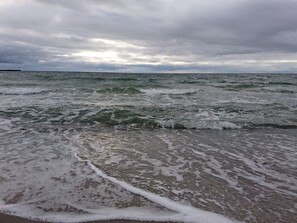 A beach with waves approaching the shore under a cloudy sky. - 4 Star Holiday Home in Bagenkop (Sydlangeland)