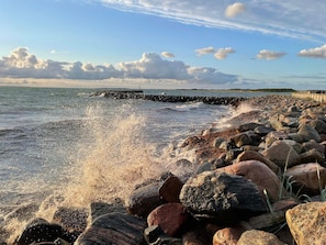 A rocky shoreline with waves crashing against it.