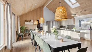A modern kitchen with a central island, pendant lighting, and a view of the outdoors.