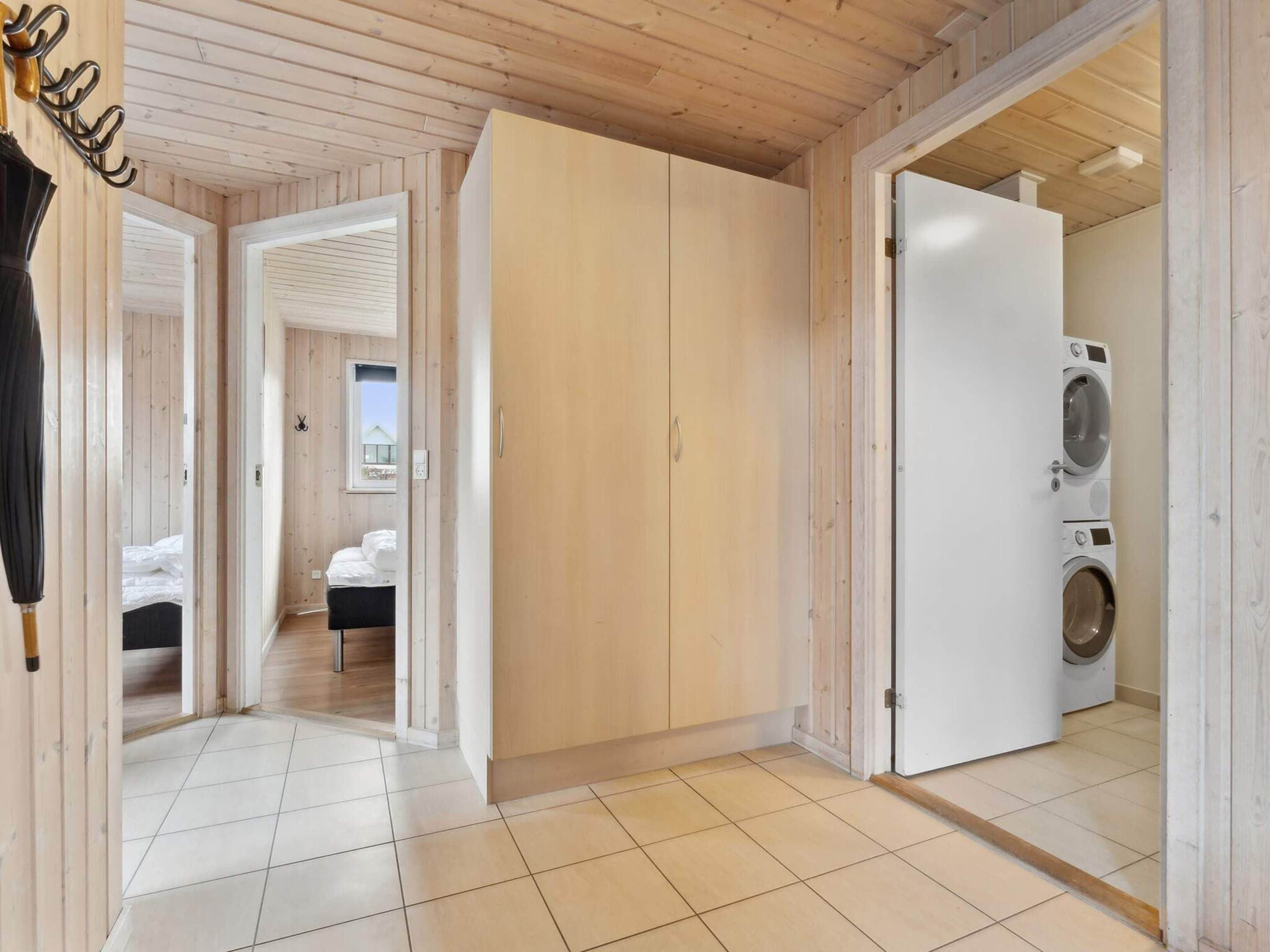 A room with a bed, a wardrobe, and a washing machine.