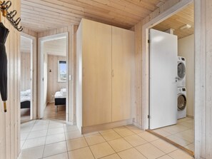 Una habitación con cama, armario y lavadora.