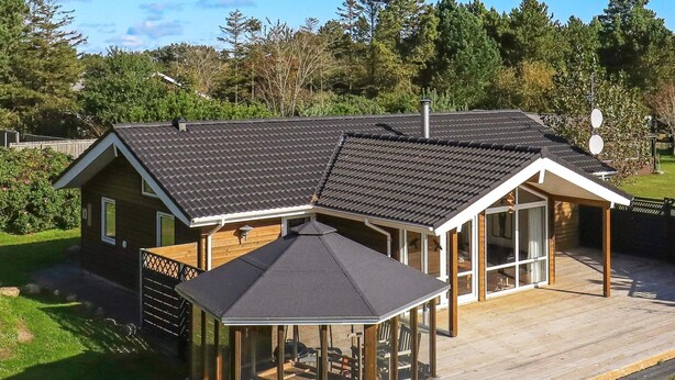 A modern house with a large deck, a covered patio, and a garage.