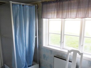 A bathroom with a shower, a window, and a radiator. - 4 Person Holiday Home in Brua Kulla (Broakulla)