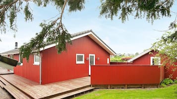 A red wooden building with a small porch and a window.