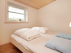 A bedroom with a bed, pillows, a window, and a view of greenery outside. - 4 Star Holiday Home in Hejls (Hejls)