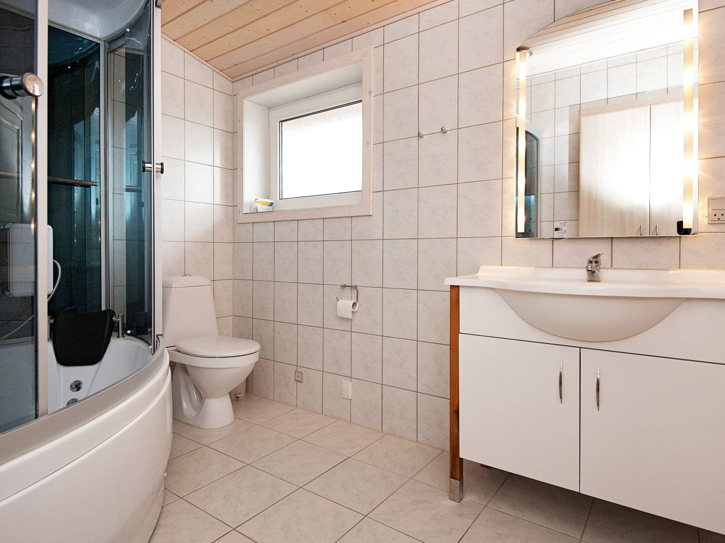 A modern bathroom with a bathtub, toilet, and sink.