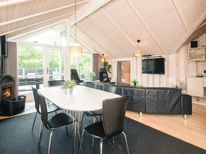 A modern interior with a dining area, seating, a fireplace, and a television. - 4 Star Holiday Home in Hemmet (Hemmet)