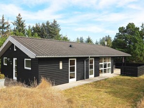 A modern black building with a sloped roof, large windows, and a covered patio area. - 4 Star Holiday Home in Albaek (Aalbaek)