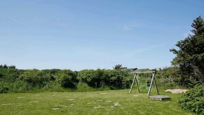 Un espace extérieur enherbé avec une balançoire.
