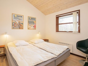 Relax in this cozy space with a double bed, two bedside tables, and a single chair.
