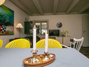 A dining area with a table, chairs, a candle, and a painting on the wall. - 4 Star Holiday Home in Asperup (Middelfart)