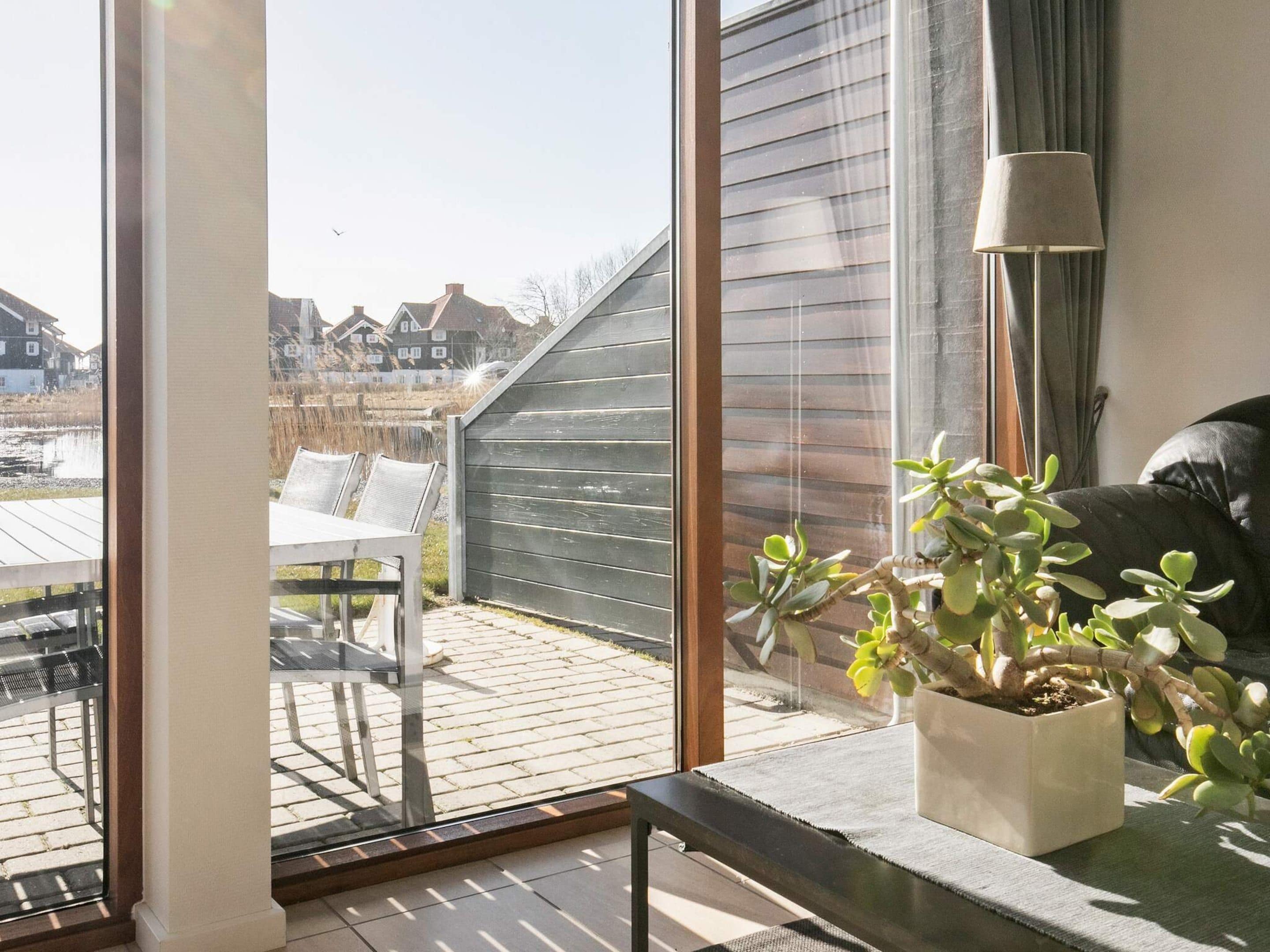 A room with a large sliding glass door leading to an outdoor patio with a table and chairs.