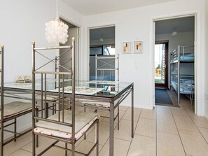 A modern interior with bunk beds, a glass table with artwork, and a chandelier. - 4 Star Holiday Home in Bogense (Bogense)