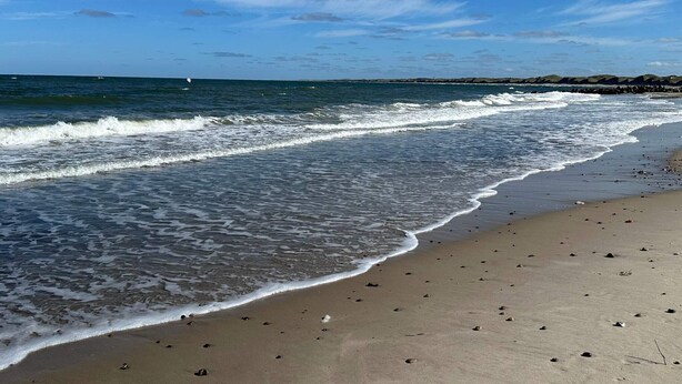 A beach with waves, a clear sky, and distant land. - 7 Person Holiday Home in Thisted (Thisted)