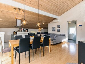 A modern kitchen with a dining area, a sofa, and a wooden ceiling. - 7 Person Holiday Home in Thisted (Thisted)