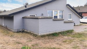 A single-story building with a grey exterior, a pitched roof, and a small window with a white frame. - 7 Person Holiday Home in Thisted (Thisted)