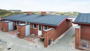A brick building with a flat roof, a door, and a small window. - 6 Person Holiday Home in Henne (Henne)