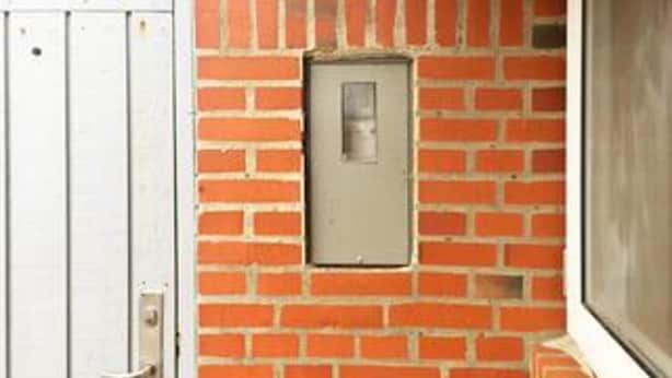 A brick wall with a rectangular electrical box and a door. - 6 Person Holiday Home in Henne (Henne)