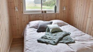 A room with a bed, a window, and wooden walls. - 5 Star Holiday Home in Sydals (Sydals)