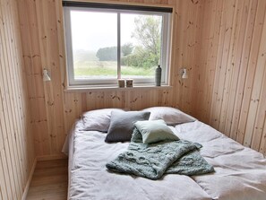 A room with a bed, a window, and wooden walls. - 5 Star Holiday Home in Sydals (Sydals)