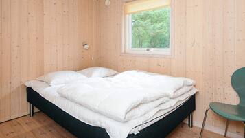 A room with a bed, a window, and a chair.