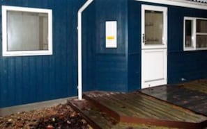 A building with a blue exterior, white doors, and windows.