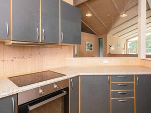 A modern kitchen with a built-in stove, oven, and granite countertop.