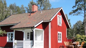 A red wooden house with a white porch and a chimney. - Holiday Home in Glesborg (Glanshammar)