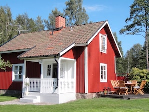 A red wooden house with a white porch and a chimney. - Holiday Home in Glesborg (Glanshammar)