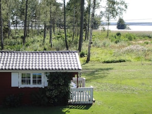 A house with a tiled roof, a white fence, and a grassy yard. - Holiday Home in Glesborg (Glanshammar)