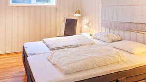 A double bed with white bedding, a bedside lamp, and a window with a view of trees. - 10 Person Holiday Home in Bygstad (Sunnfjord)