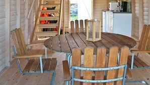 A wooden interior with a round table and chairs, a staircase, and a kitchen area. - Holiday Home in HÃ¤lleviksstrand (Hälleviksstrand)