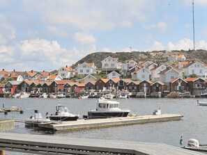 A harbor with boats docked, a pier, and a row of houses with red roofs. - Holiday Home in HÃ¤lleviksstrand (Hälleviksstrand)