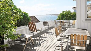 A wooden deck with outdoor seating, overlooking a body of water. - Holiday Home in HÃ¤lleviksstrand (Hälleviksstrand)