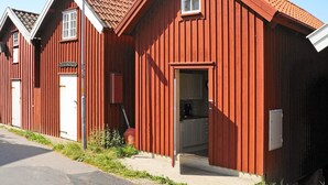 A red wooden building with a sloped roof, a visible door, and a window. - Holiday Home in HÃ¤lleviksstrand (Hälleviksstrand)